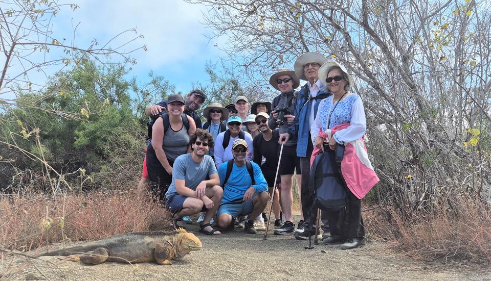Grupo de viajeros junto a una iguana terrestre