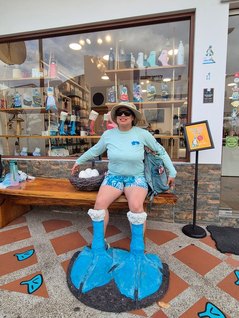 Viajera posando con una escultura de las patas azules de un piquero