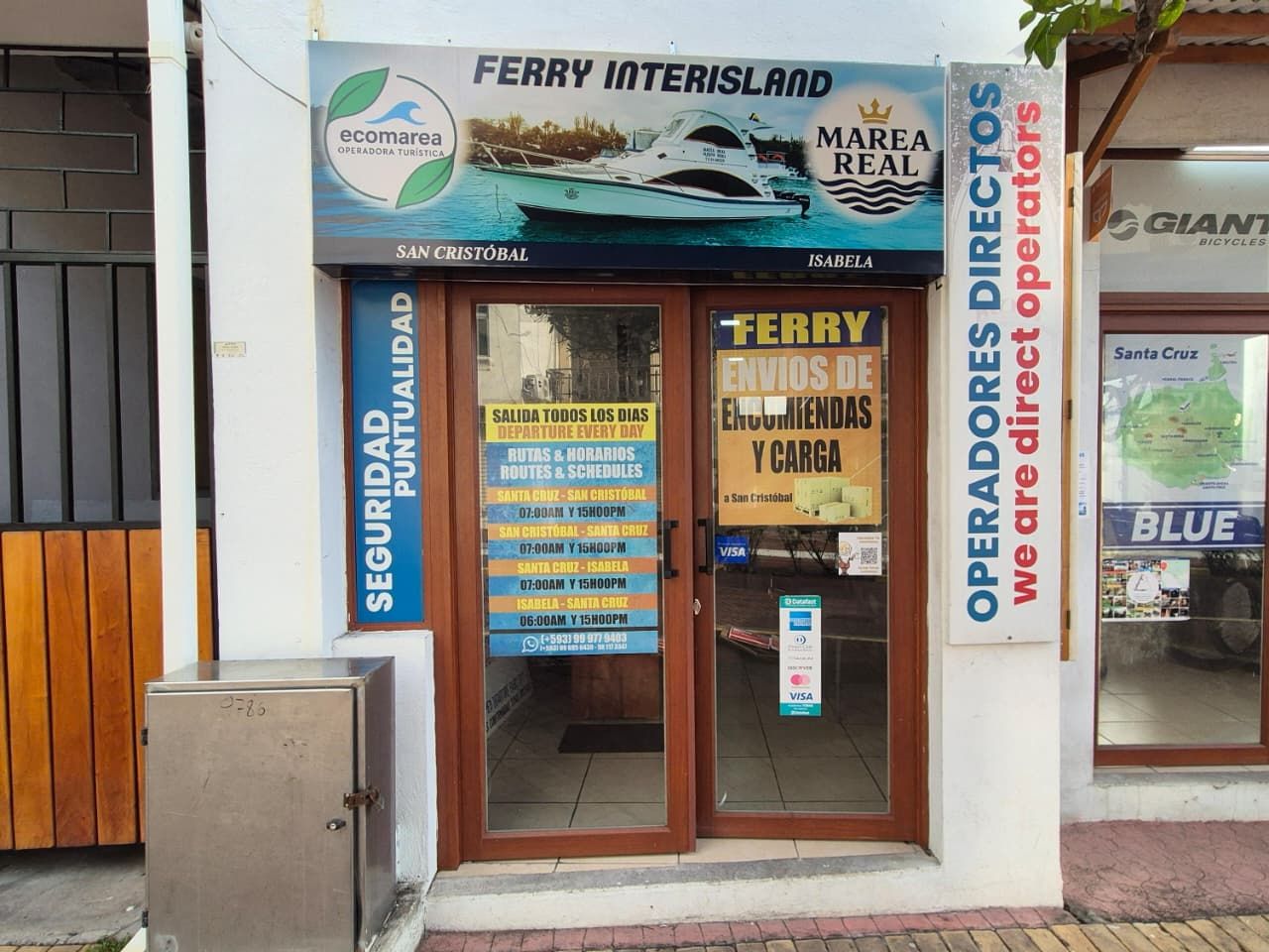 Fachada de la oficina de Ecomarea en Puerto Ayora, con el letrero de Ferry Interisland y la lancha Marea Real