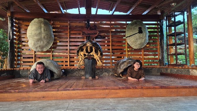 Dos viajeros asomados desde caparazones de tortuga gigante en el rancho