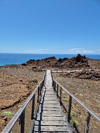 Pasarela de madera hacia el mirador de Bartolomé, con el mar al fondo